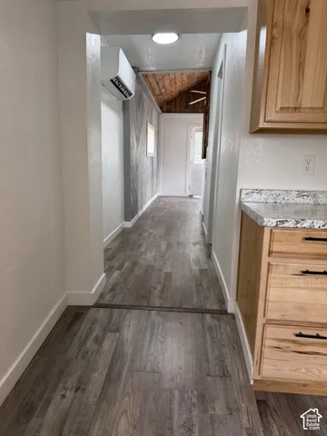 Corridor featuring wood-finish flooring, light-toned walls, and a mini-split HVAC unit