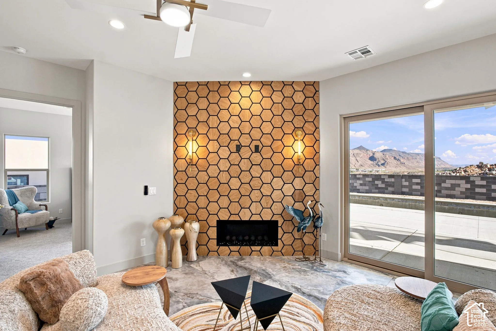 Accent wall featuring geometric wood-finish tiles, built-in fireplace, and integrated sconce lighting