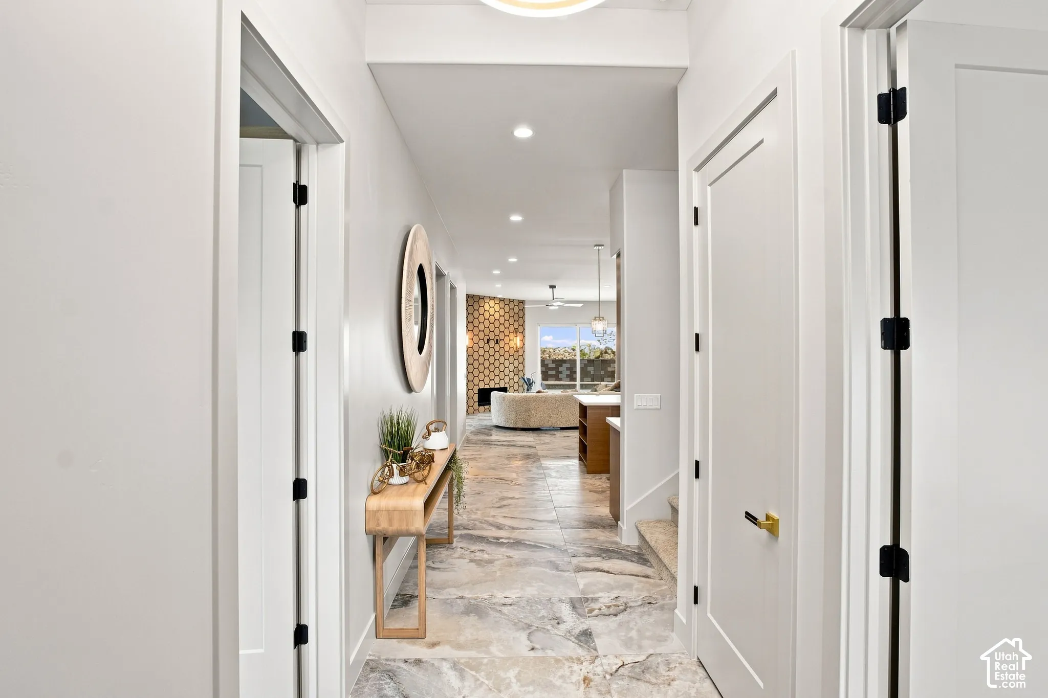 Hallway with stone-finish flooring, recessed lighting, and solid panel doors featuring black hardware