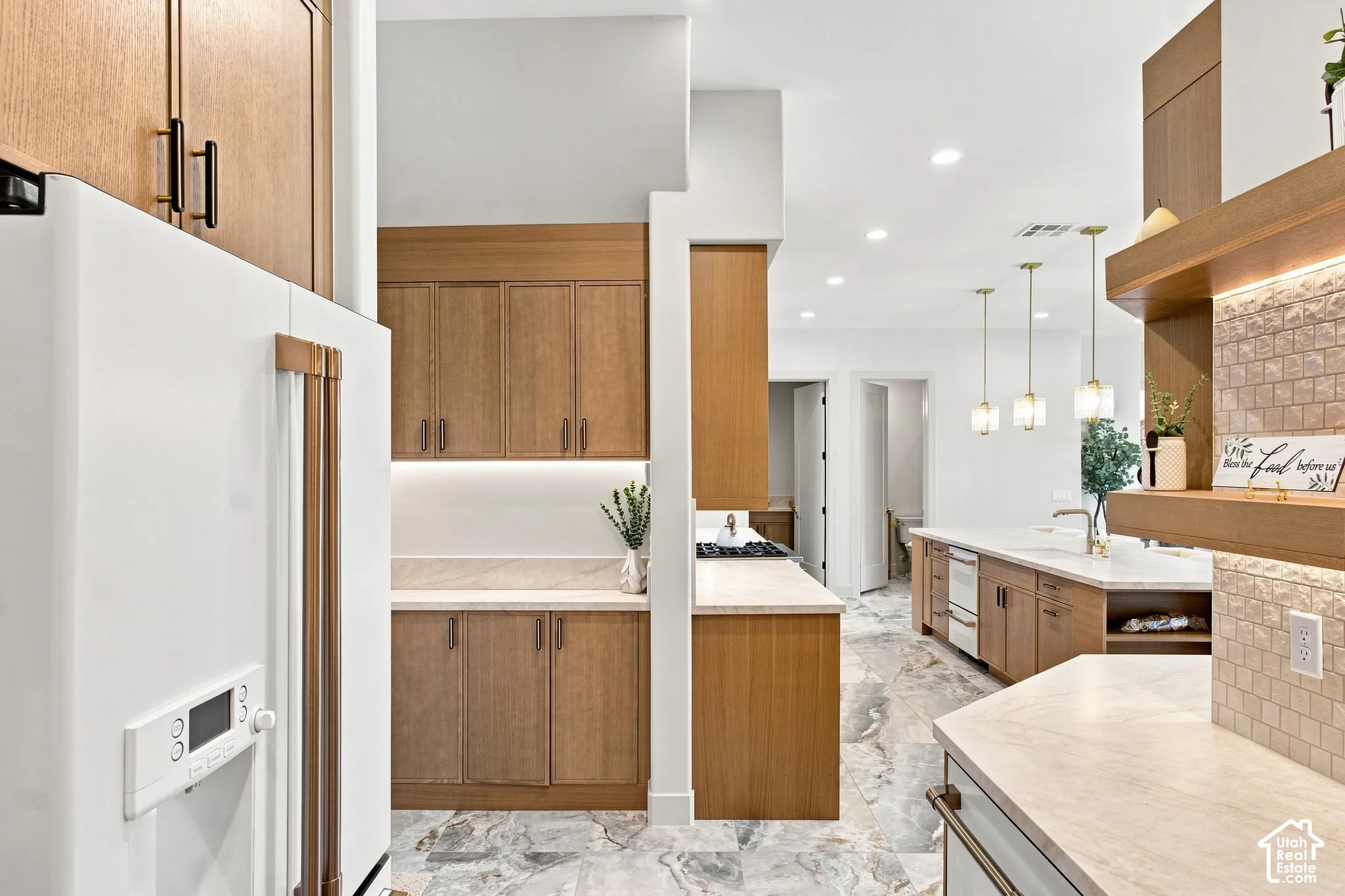 Kitchen featuring wood-finish cabinetry, light-toned countertops, and recessed lighting
