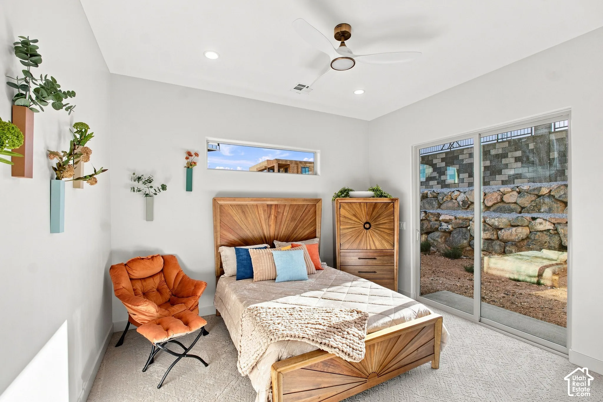 Recessed lighting, ceiling fan, wood-finish bed frame, horizontal transom window, and sliding glass door to exterior