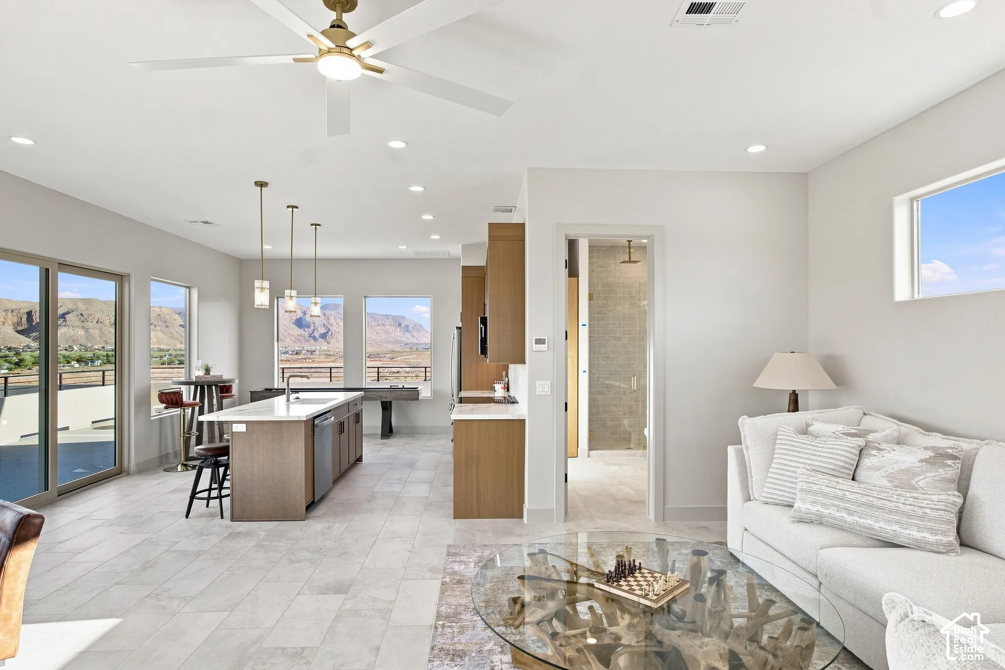 Open-concept living area featuring a ceiling fan, recessed lighting, and large format tile flooring