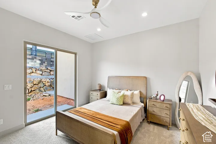 Recessed lighting, ceiling fan, sliding glass door, neutral wall tones, and carpeted flooring