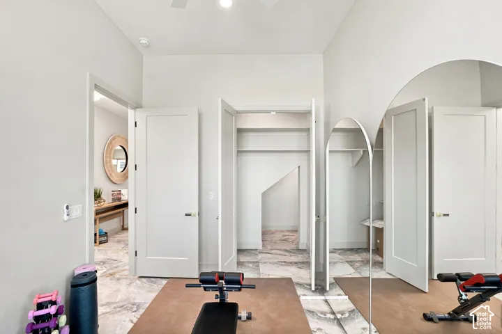 Interior room featuring light gray walls, white flat-panel doors, and a marble-look tile floor