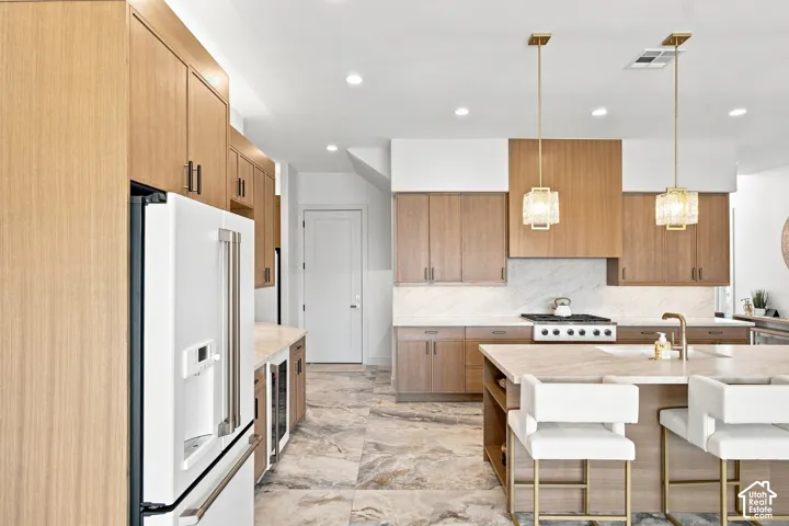 Modern kitchen featuring wood-finish cabinetry, recessed lighting, and a large central island with seating