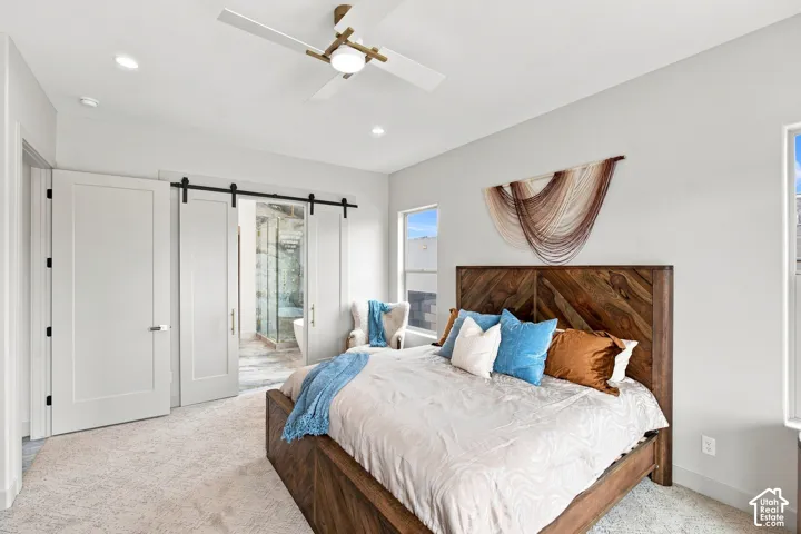 Barn door entry leading to a bathroom, recessed lighting, and a modern ceiling fan