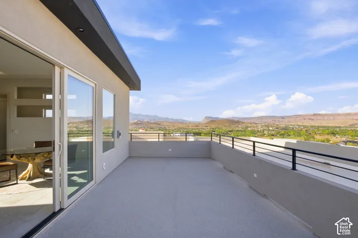 Expansive rooftop terrace with black metal railing, offering broad distant scenery