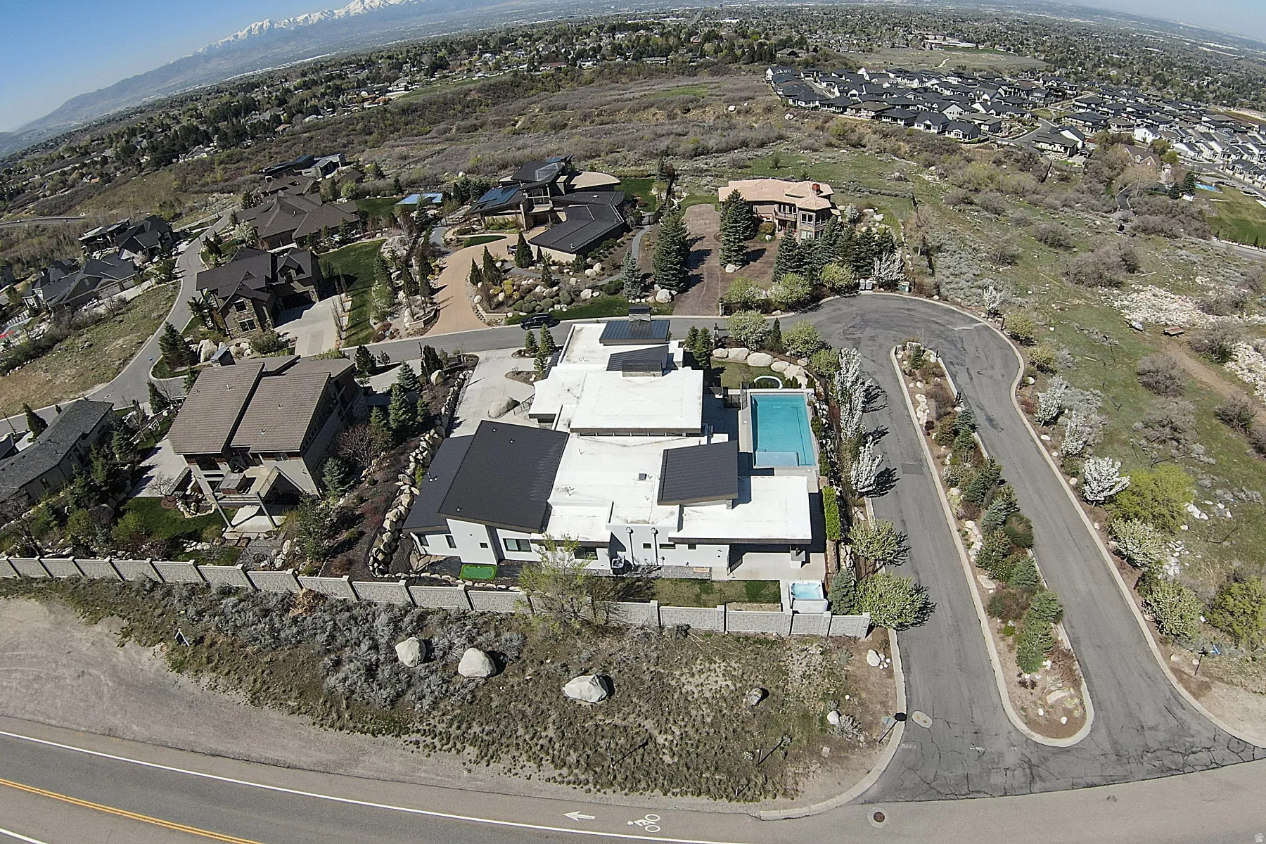 Modern architectural style featuring multiple flat roofs, an in-ground swimming pool, and solar panels