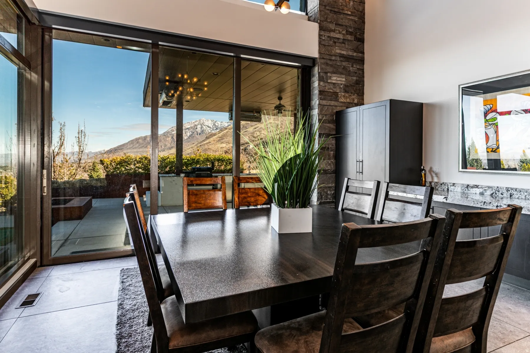 Dining area featuring a dark wood-finish table and chairs, a stone accent wall, and built-in cabinetry