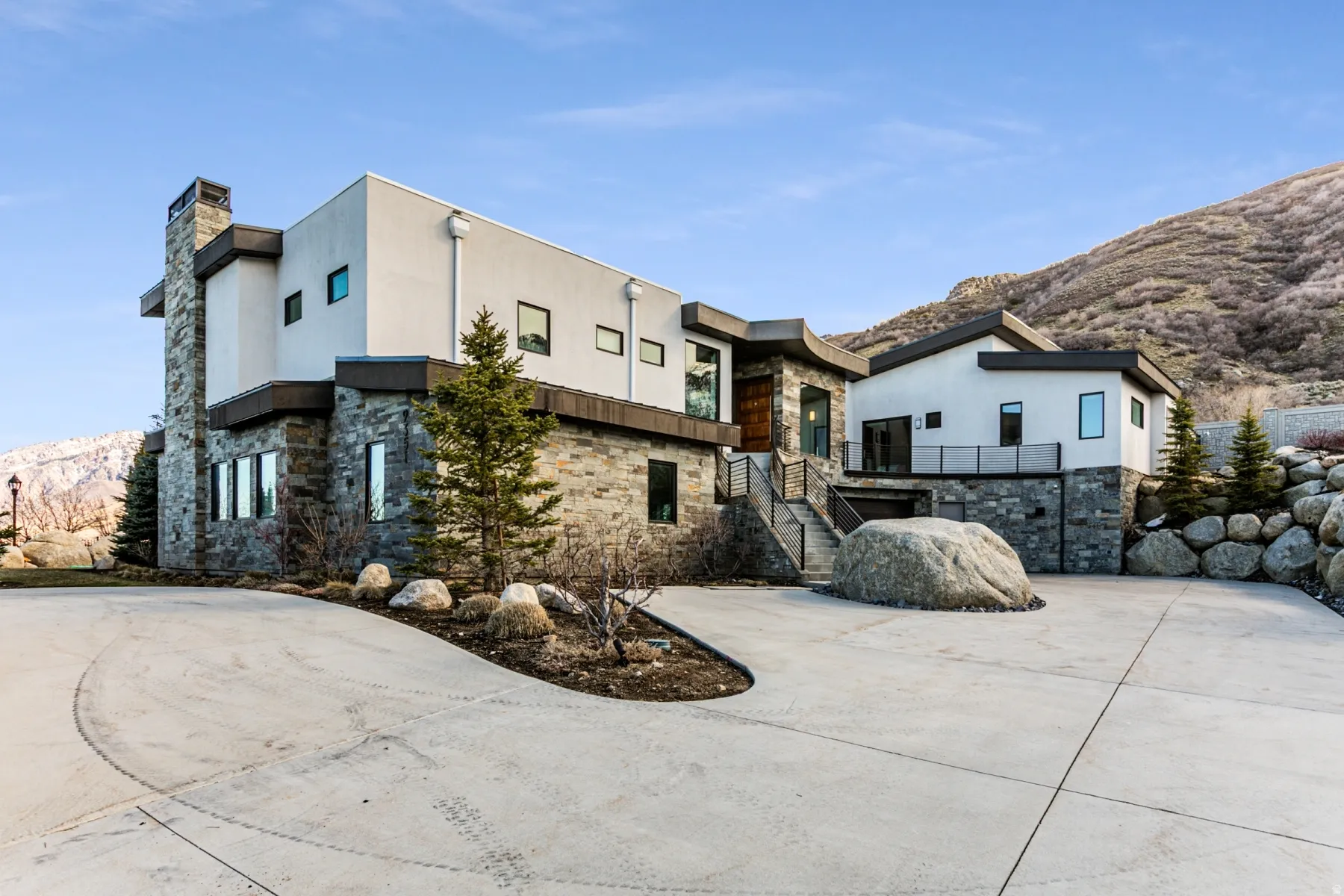 Contemporary multi-level residence featuring a stucco and stone exterior