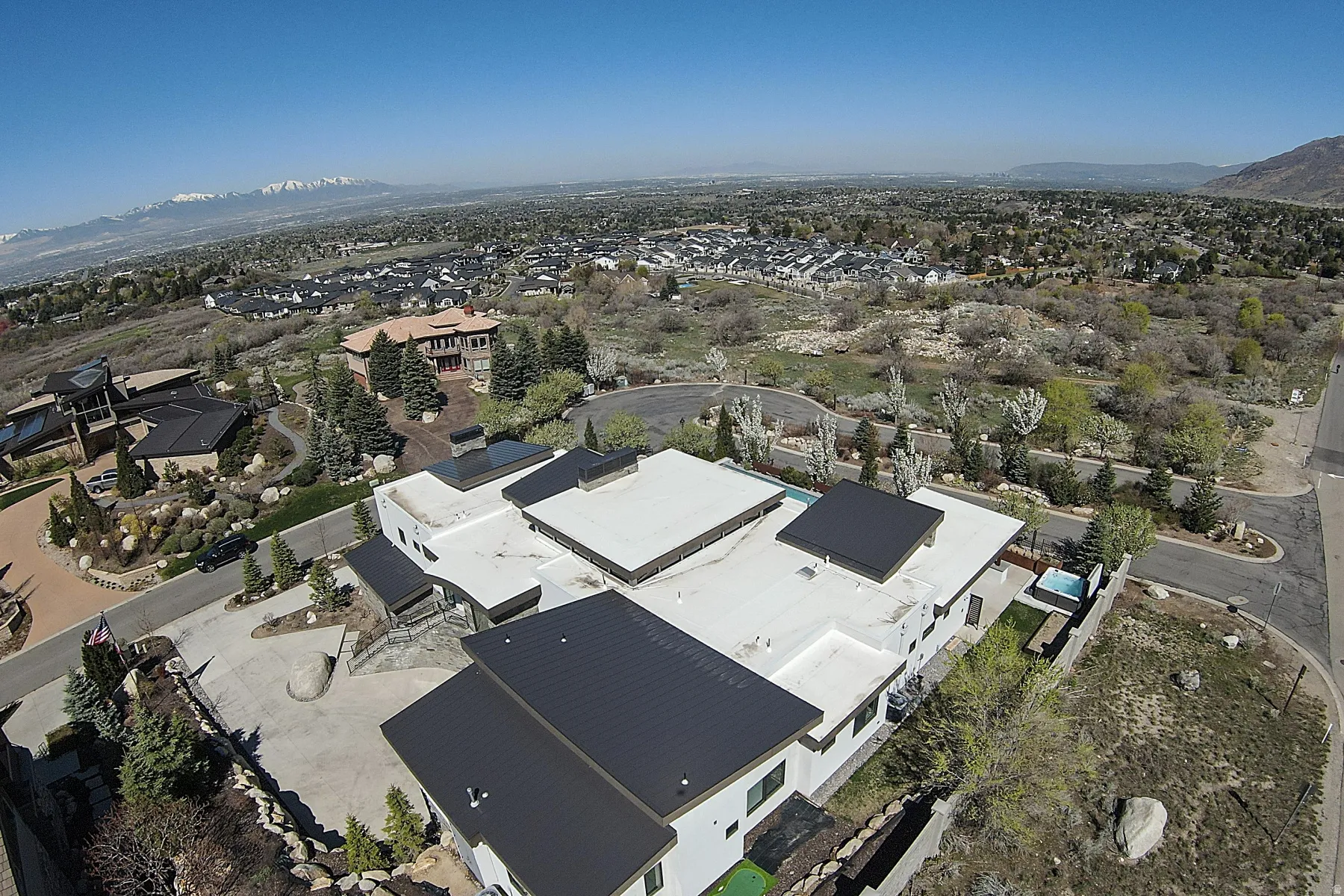 Contemporary residence featuring multiple black metal roofs and white flat roof sections