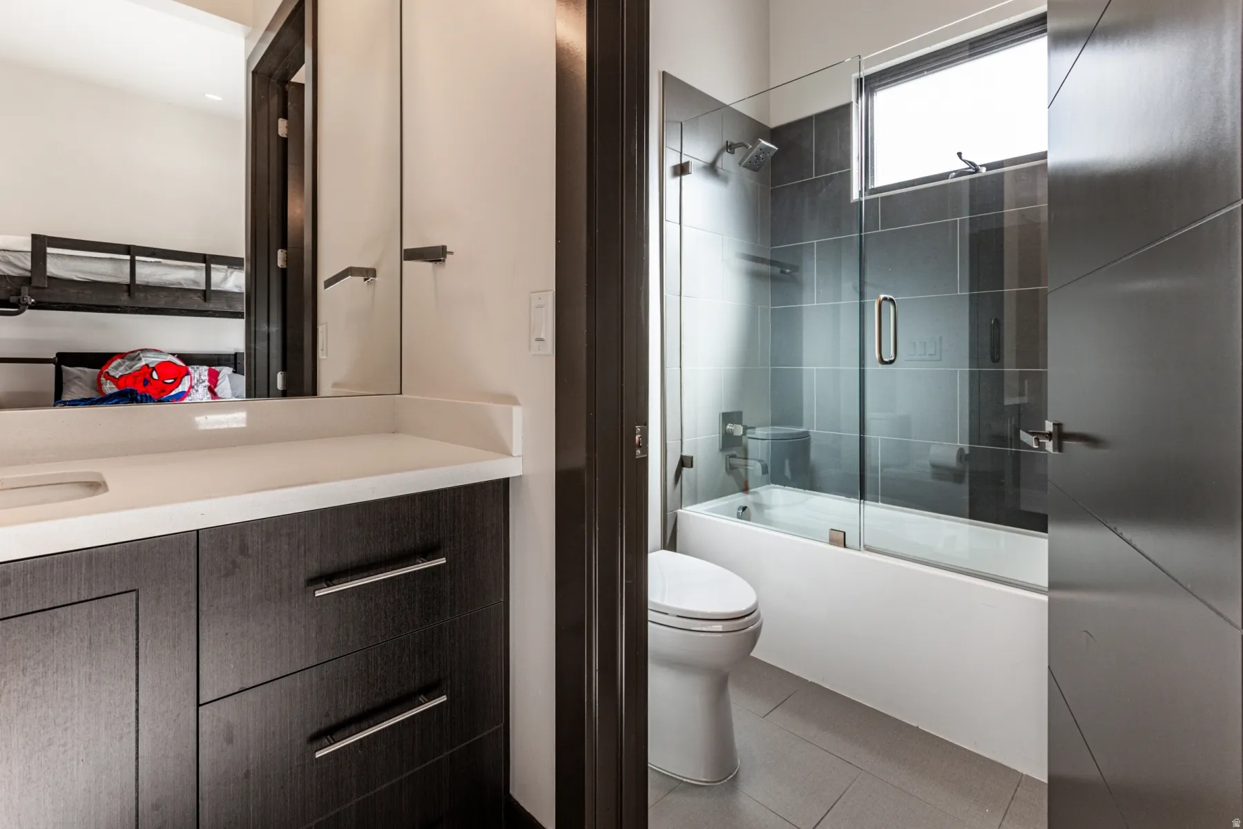 Bathroom 2 featuring a wood-finish vanity with a light-toned countertop and an undermount sink