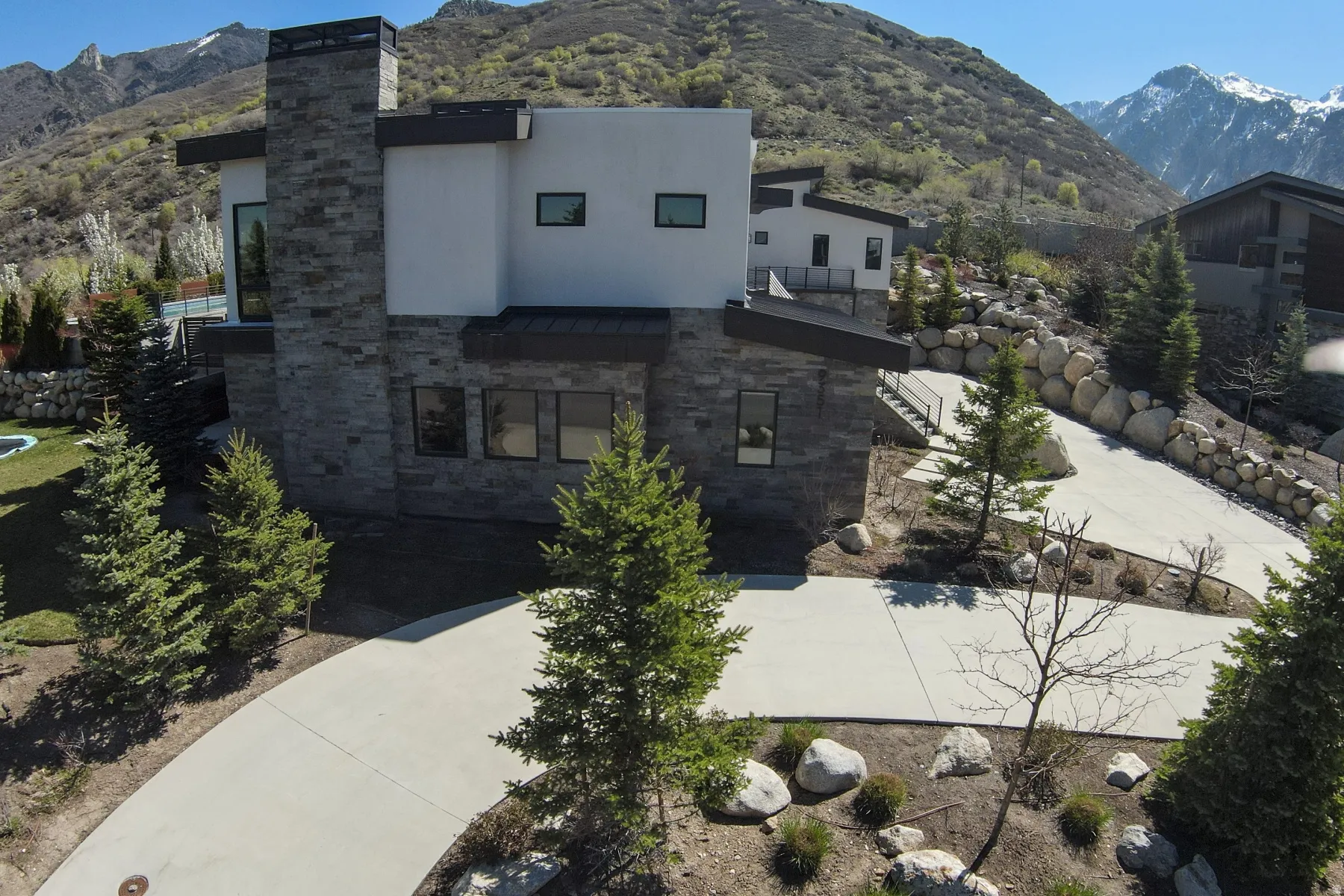Contemporary exterior featuring stone cladding and white stucco finishes
