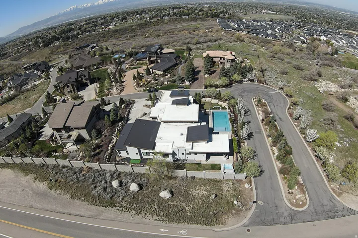 Modern architectural style featuring multiple flat roofs, an in-ground swimming pool, and solar panels