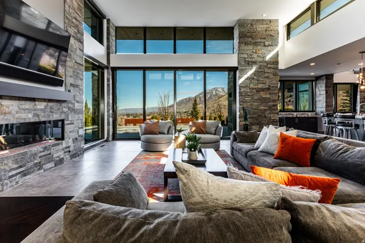 Expansive living area featuring soaring ceilings and a floor-to-ceiling stone fireplace