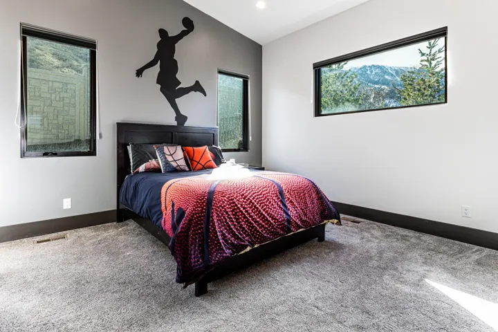 Spacious bedroom 3 featuring light gray walls with a dark accent wall, recessed lighting, and dark wood-finish trim