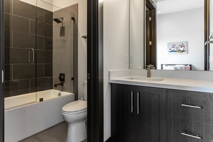 Modern bathroom 5 featuring a dark wood-finish vanity with a white countertop and undermount sink