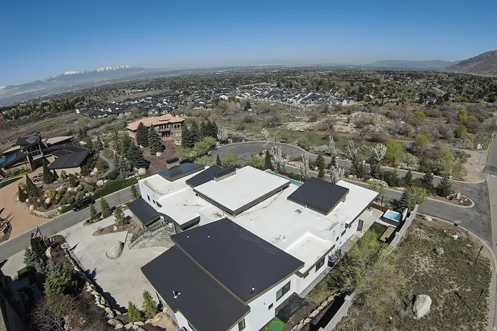 Contemporary residence featuring multiple black metal roofs and white flat roof sections