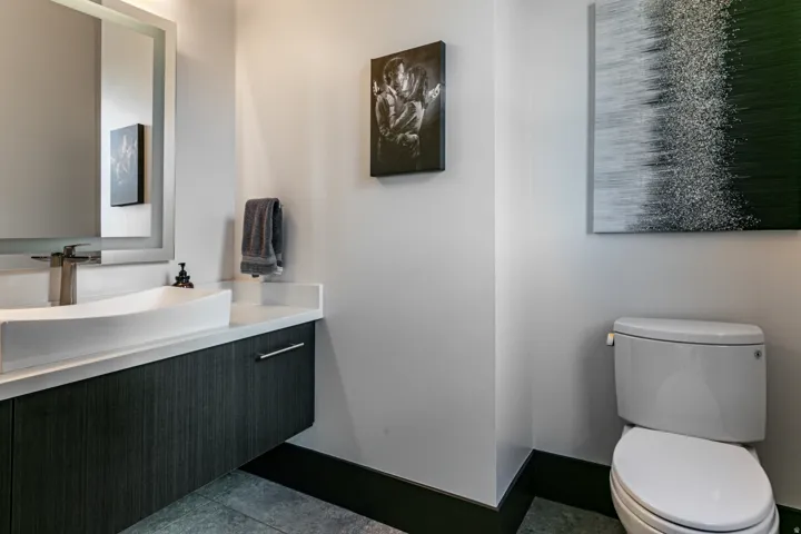 Modern powder room by kitchen featuring a floating vanity with dark wood-finish cabinetry, a white rectangular vessel sink, and a single-handle faucet