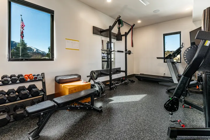 Dedicated fitness room featuring specialized rubber flooring, recessed lighting, and white walls