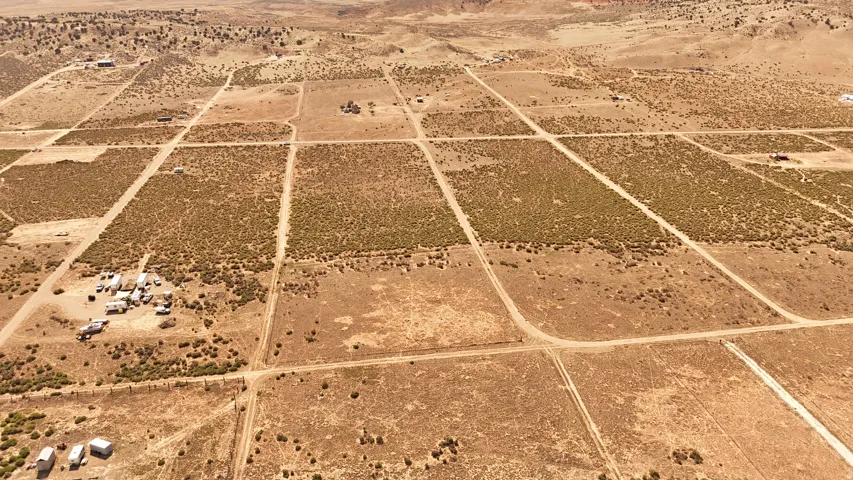 Expansive desert landscape with multiple distinct parcels defined by unpaved roads and subtle vegetation changes