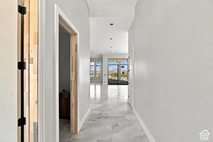 Hallway featuring large format tiled flooring, recessed lighting, and expansive windows