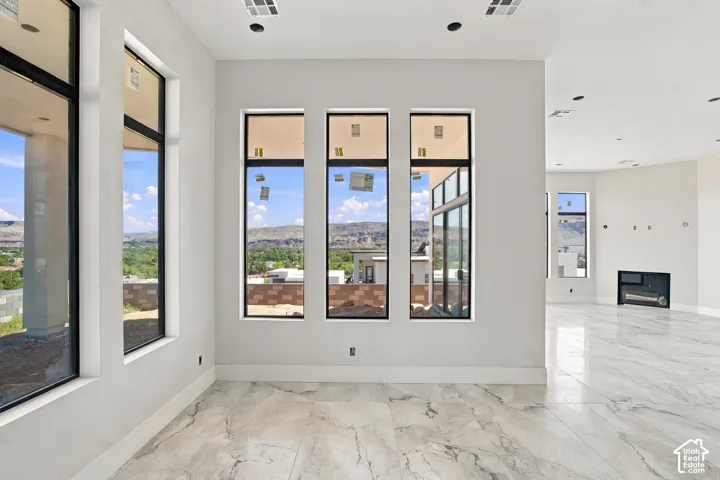Spacious interior with large format tile flooring, recessed lighting, and a built-in fireplace