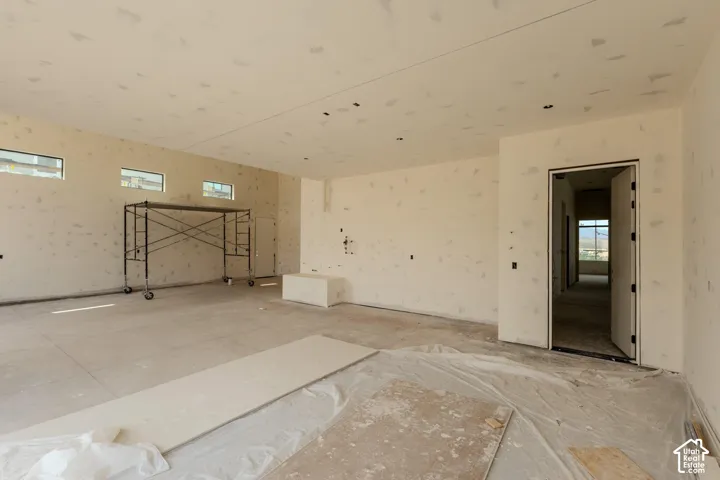 Spacious interior featuring multiple rectangular transom windows, a wide doorway, and concrete flooring
