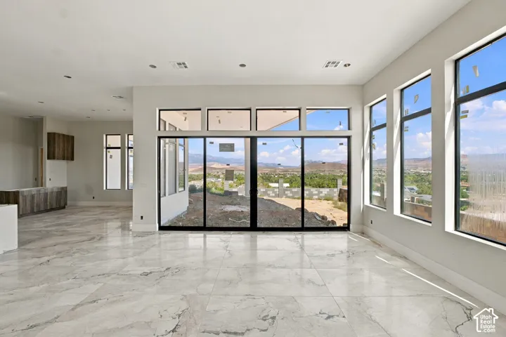 Large format tile flooring, expansive windows, multiple glass sliding doors, recessed lighting, and modern cabinetry
