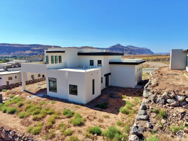 Contemporary multi-level exterior with flat rooflines, large black-framed windows, and white stucco finish