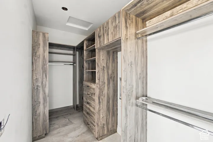 Custom built-in closet system with wood-finish cabinetry, integrated shelving, and multiple hanging rods