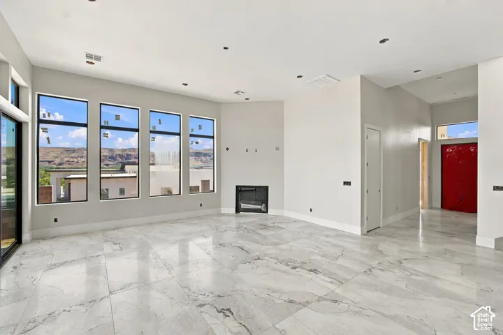 Spacious interior with large format tile flooring, recessed lighting, and an integrated fireplace