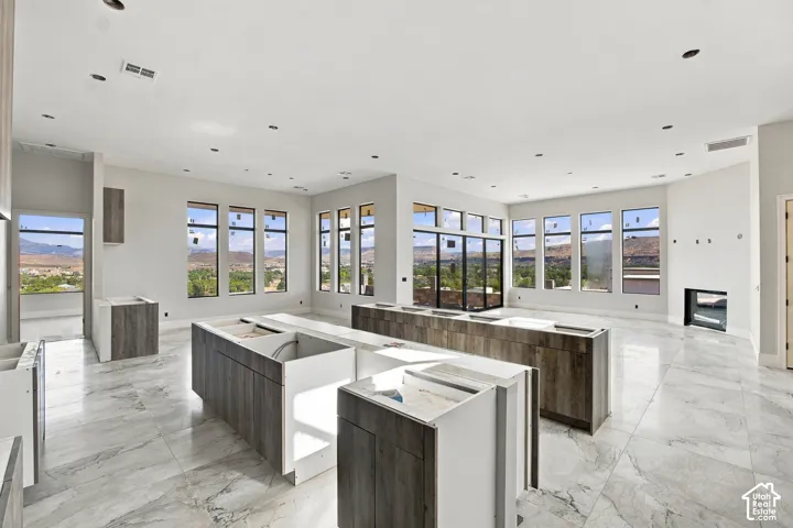 Spacious interior featuring marble-finish flooring, recessed lighting, and multiple large windows