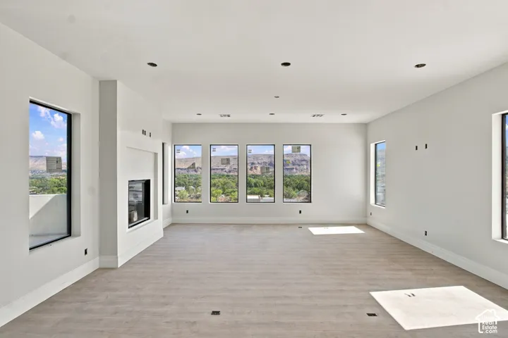 Recessed lighting, wood-finish flooring, multiple windows, built-in fireplace, and expansive wall space