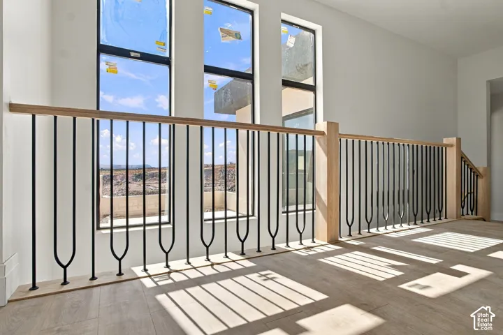 Light wood-finish flooring, white walls, and three tall vertical windows with black frames
