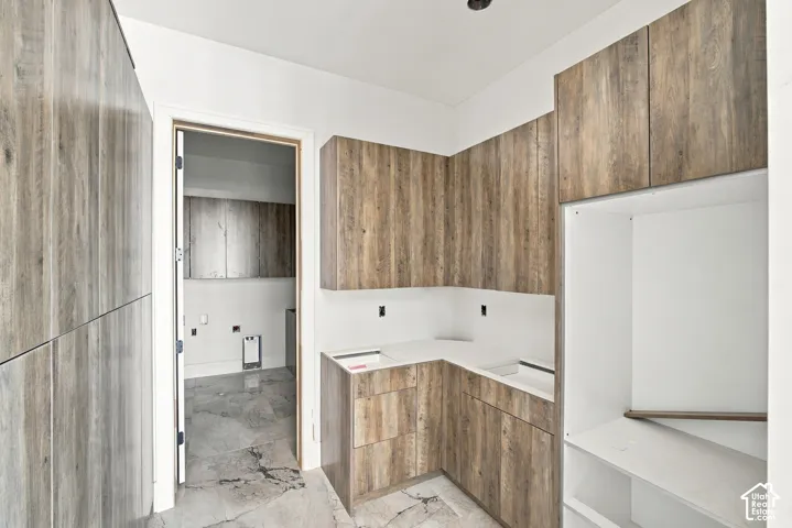 Wood-finish cabinetry and built-in shelving, complemented by white countertops and a recessed ceiling light