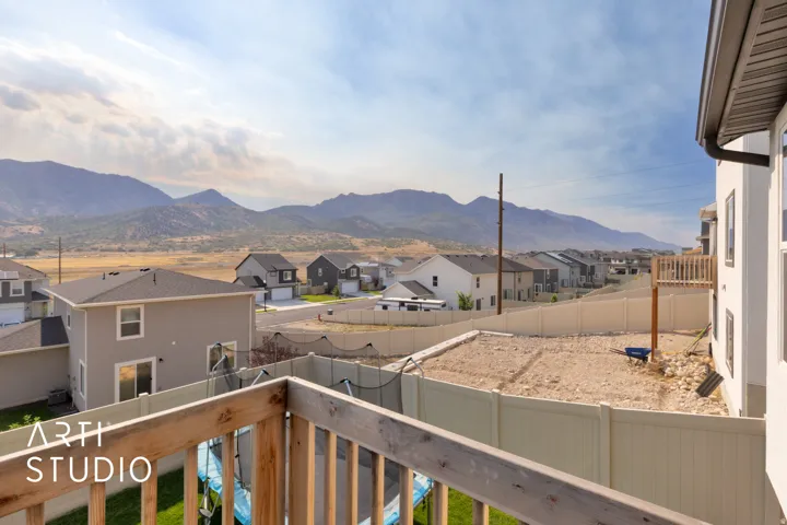 Expansive mountain backdrop with a gravel lot and a wooden deck