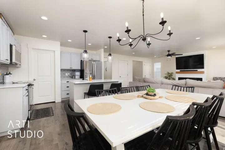 Open-concept living space with wood-finish flooring, recessed lighting, and a white dining table