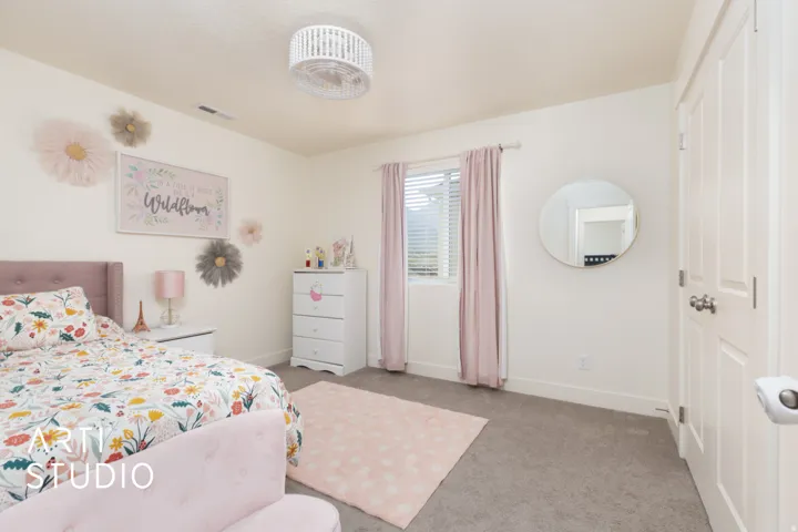 Carpeted room featuring a window with blinds and drapes, a white paneled door, and a decorative ceiling light fixture