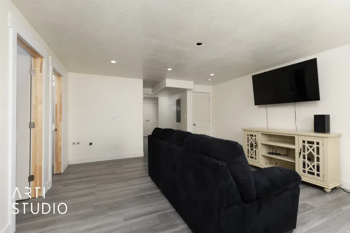 Spacious room featuring light gray wood-finish flooring, recessed lighting, and crisp white walls