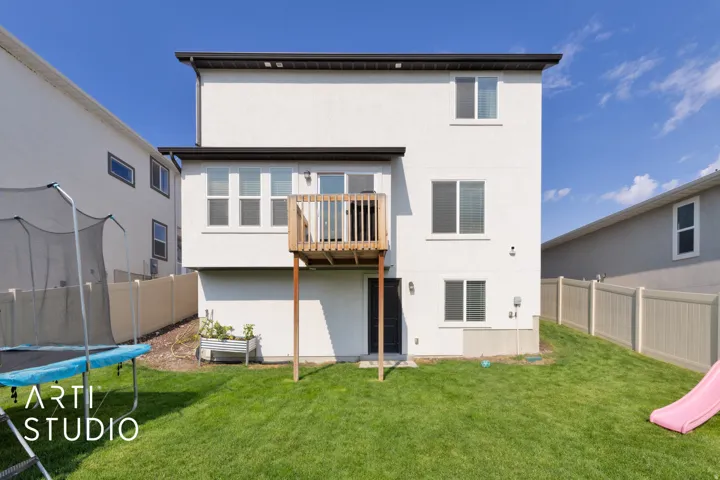 Contemporary white exterior featuring multiple windows and a wooden deck