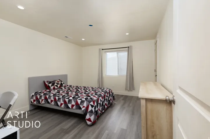 Neutral walls featuring recessed lighting, wood-finish flooring, and a window with blinds and drapes