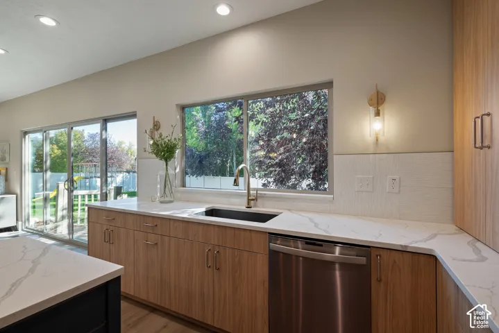 The kitchen brings the outdoors in through layered window views and a wide galley-style walkway, complemented by convenient touch-faucet technology.