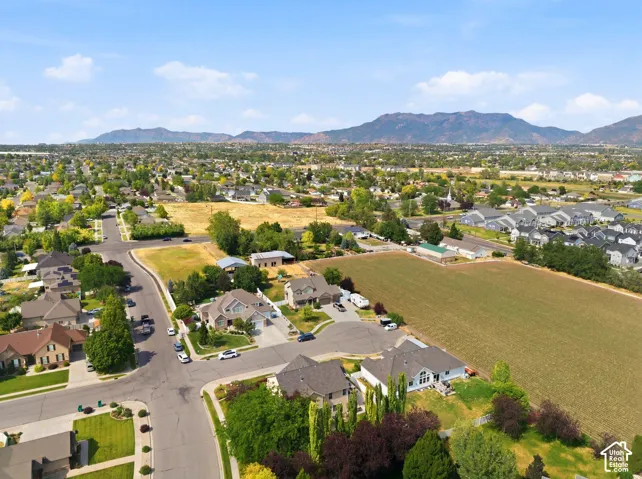 Expansive rural landscape featuring a prominent mountain range backdrop and scattered residential developments