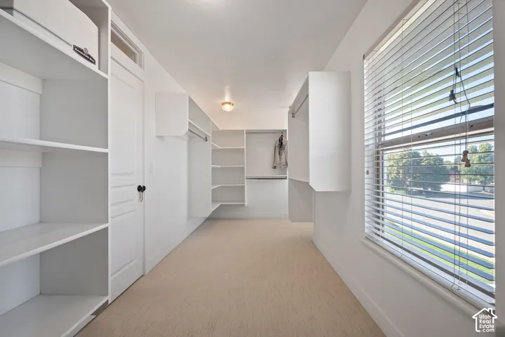 Crisp, beautifully appointed primary closet with two windows and generous proportions. The natural light and ample room create the feel of a true luxury dressing space.