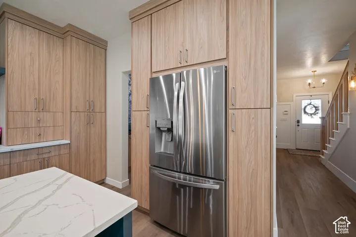 Recessed double refrigerator framed by floor-to-ceiling cabinetry, with a built-in charging station and extensive storage integrated throughout.
