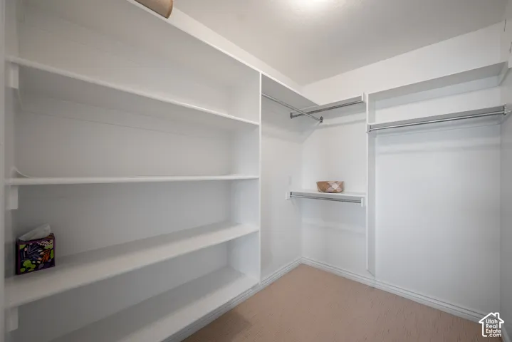 Ensuite walk-in closet with built-in shelving and clothing rods for easy organization.