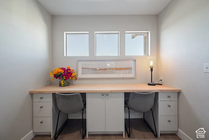 Dedicated office or homework station with linen-look built-in cabinetry, filing drawers, shelving, and a cleverly concealed printer cabinet.