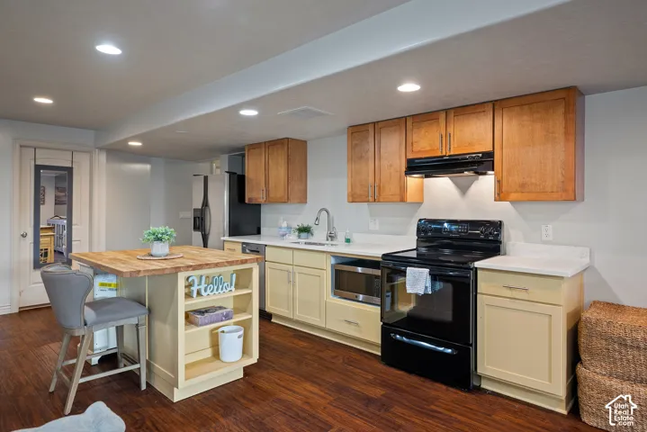 Second kitchen featuring warm butter-yellow and wood-tone cabinetry for a welcoming, residential feel.