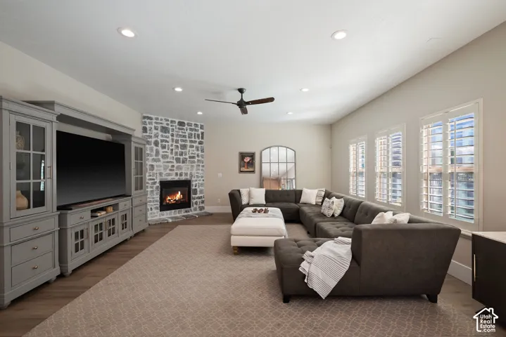 Inviting great room with three plantation-shuttered windows and a beautiful stone gas fireplace, creating a comfortable hub for family gatherings.